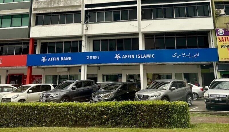 Pandangan hadapan cawangan AFFIN Bank Sibu dan AFFIN ISLAMIC di rumah kedai dengan barisan kereta diletakkan di bahagian hadapan.