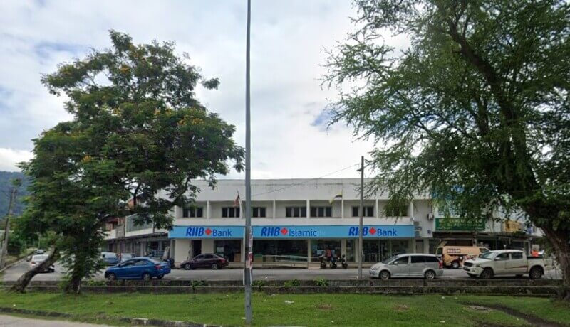 Pandangan hadapan bangunan cawangan RHB Bank Jelapang dan RHB Islamic dengan papan tanda biru, serta beberapa kenderaan yang diletakkan di sepanjang jalan di hadapannya.