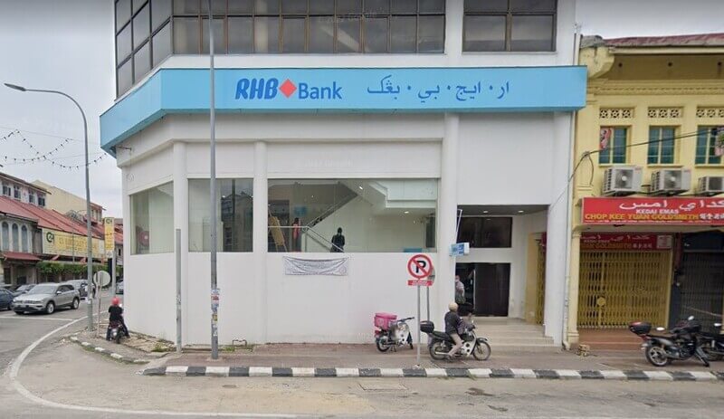 Pandangan luar cawangan RHB Bank dua tingkat berwarna putih di sudut jalan di Kota Bharu, memaparkan papan tanda dalam tulisan Inggeris dan Jawi