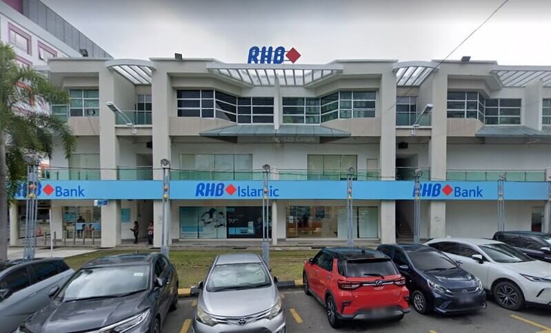 Pandangan luar bangunan Bank RHB dan cawangan RHB Islamic berwarna putih tiga tingkat di Metro Town, menampilkan papan tanda biru yang menonjol dan kawasan parkir di hadapan