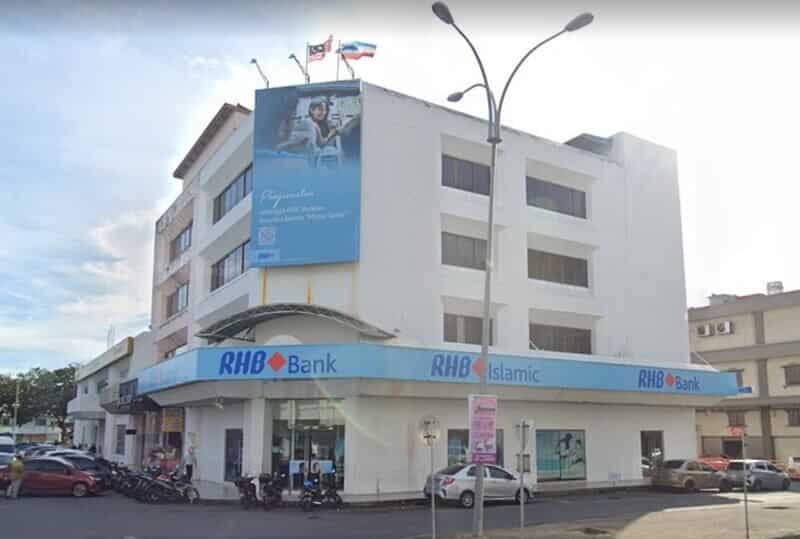 Sebuah bangunan bertingkat putih RHB Bank dan cawangan RHB Islamic yang terletak di sudut jalan di Tawau, Malaysia, menampilkan papan iklan promosi biru yang besar di bahagian hadapan