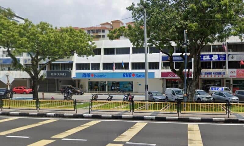 Bahagian luar cawangan RHB Bank dan RHB Islamic di Butterworth, Jalan Kampung Gajah, yang terletak di sebuah bangunan rumah kedai bertingkat berwarna putih, mempunyai papan tanda kedai biru dan kenderaan yang diletakkan di sepanjang jalan