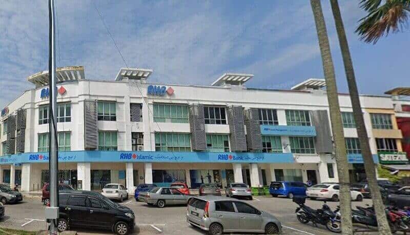 Satu gambar siang hari yang luas menunjukkan Bank RHB dan cawangan RHB Islamic di Dataran Putra di Kuantan, menampilkan bahagian luar bertingkat berwarna putih dengan papan tanda biru dan kereta yang diletakkan di hadapan