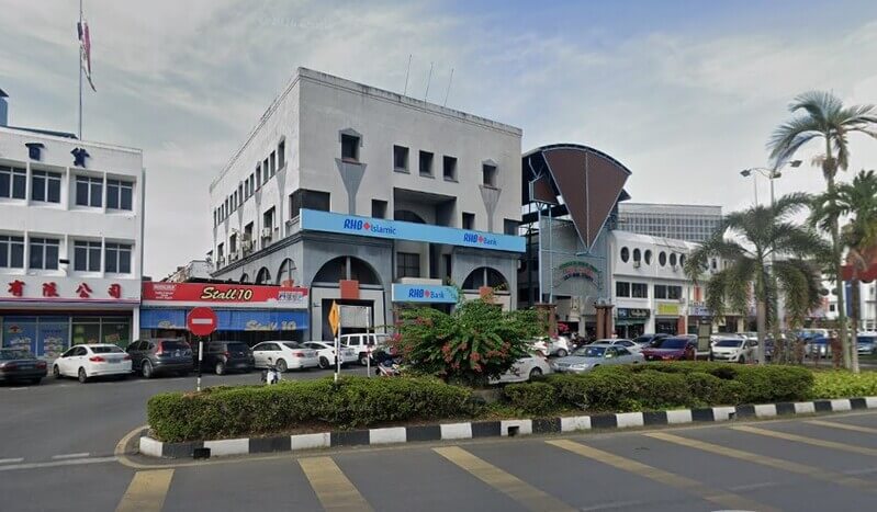 Pemandangan luar bangunan cawangan RHB Islamic dan RHB Bank di Jalan Nakhoda Gampar dengan deretan kedai dan kereta diletakkan di hadapannya.