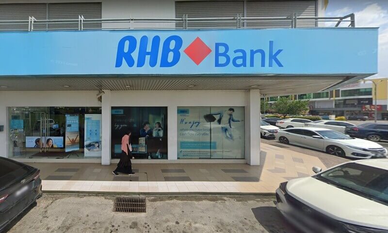 Bahagian luar kedai RHB Bank cawangan Inanam di Kota Kinabalu, Sabah, menampilkan papan tanda jenama biru dan tingkap kaca besar dengan poster promosi