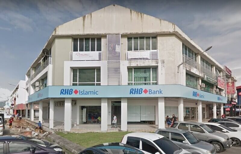 Pandangan luar bangunan kedai tiga tingkat yang memaparkan papan tanda RHB Bank dan RHB Islamic di tingkat bawah, yang terletak di Matang Jaya dengan kereta yang diletakkan di hadapan