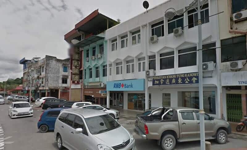 Paparan aras jalan cawangan RHB Bank yang terletak di sebuah rumah kedai bertingkat putih di Kanowit, Sarawak, dengan kereta yang diletakkan di sepanjang jalan dan perniagaan bersebelahan kelihatan