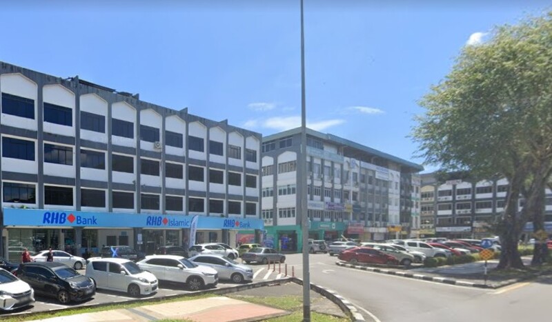 Pemandangan luar cawangan RHB Bank Sibu dan RHB Islamic di deretan bangunan kedai empat tingkat dengan kawasan tempat letak kereta di hadapannya.