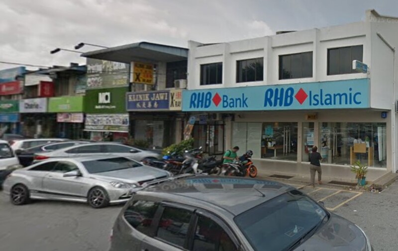 Pandangan hadapan Bank RHB dan cawangan RHB Islamic di Sungai Bakap, memaparkan papan tanda jenama biru dan kedai kaca dengan motosikal yang diletakkan di hadapan