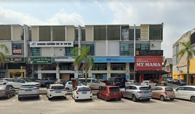 Pemandangan luar deretan rumah kedai yang menempatkan cawangan bank RHB Bank di Jalan Air Putih dan restoran Nasi Kukus My Mama, dengan kawasan tempat letak kereta yang sibuk di hadapannya