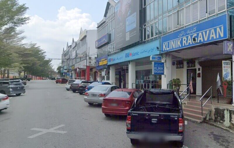 Deretan kedai komersial di tepi jalan yang menempatkan RHB Bank Raub, RHB Islamic, dan Klinik Ragavan bersama kenderaan yang diletakkan di hadapannya