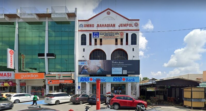 Pemandangan hadapan bangunan cawangan RHB Bank Bahau dan RHB Islamic yang menempatkan Pejabat UMNO Bahagian Jempol di tingkat atas, bersebelahan premis Guardian dan 7-Eleven.