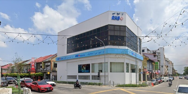 Bangunan cawangan RHB Bank Kota Bharu dan RHB Islamic bertingkat di persimpangan jalan bandar pada waktu siang dengan kenderaan lalu-lalang