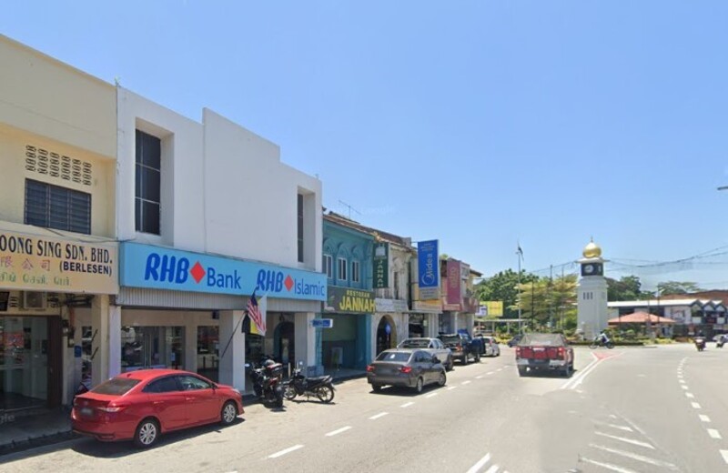 Pemandangan jalan di Kuala Kangsar yang menunjukkan cawangan RHB Bank Kuala Kangsar dan RHB Islamic di barisan rumah kedai, dengan kenderaan diletakkan di tepi jalan serta menara jam berkubah emas di latar belakang