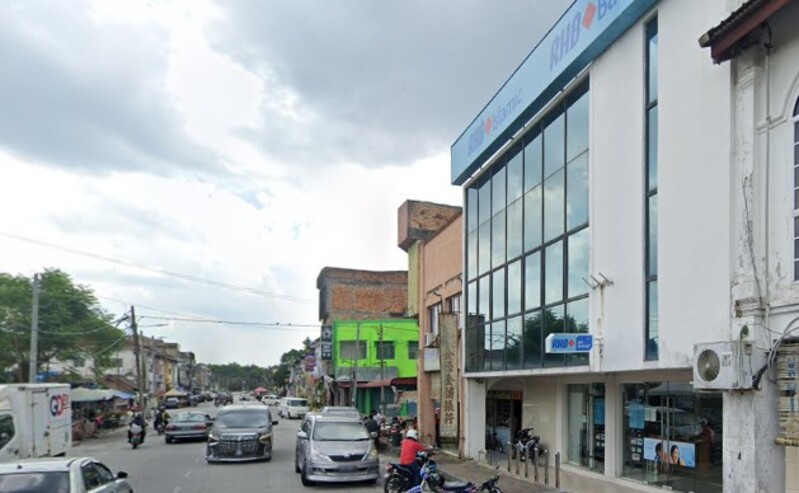 Pemandangan luar cawangan RHB Bank di Sungkai, menampilkan bahagian hadapan panel kaca moden dan pintu masuk aras jalan dengan motosikal diletakkan di hadapan