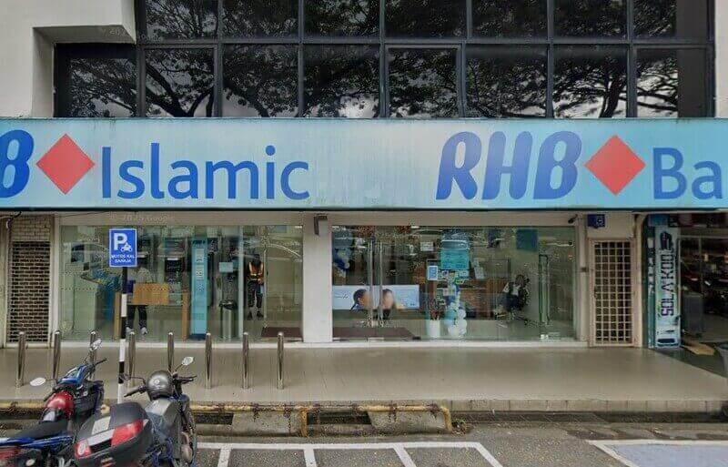 Bahagian luar cawangan RHB Islamic Bank di Kulai, memaparkan papan tanda jenama biru dan merah di atas pintu masuk kaca, dengan motosikal yang diletakkan di latar depan