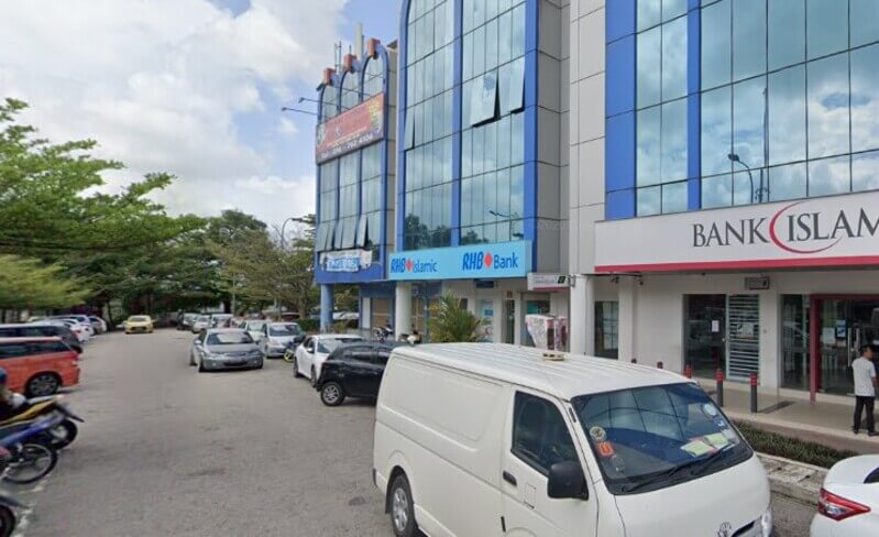 Pandangan luaran deretan bangunan komersial yang menempatkan cawangan RHB Bank Pasir Gudang, RHB Islamic, dan Bank Islam, dengan ruang tempat letak kereta dan sebuah van putih di bahagian hadapan