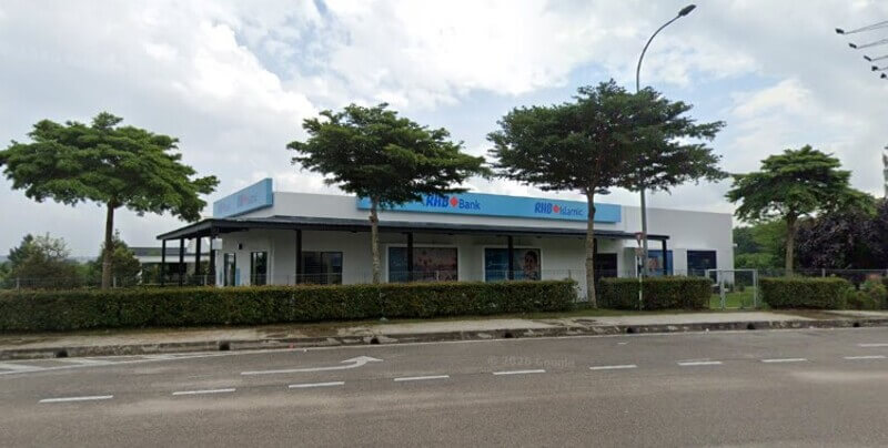 Pemandangan luar bangunan cawangan RHB Bank dan RHB Islamic berserta papan tanda biru dan pokok-pokok di bahagian hadapan