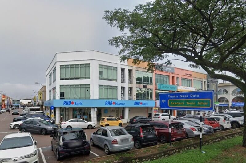 Pandangan luar cawangan RHB Bank Taman Nusa Bestari dan RHB Islamic di bangunan sudut dengan tempat letak kereta dan papan tanda jalan