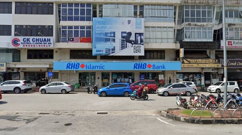 Pandangan hadapan premis cawangan RHB Bank Sungai Petani dan RHB Islamic di deretan bangunan kedai dengan kenderaan diletakkan di bahu jalan