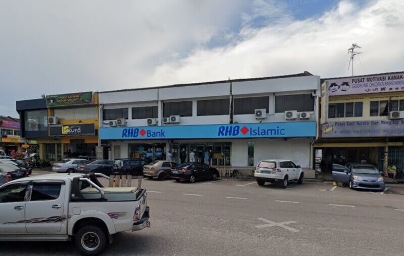 Papan tanda cawangan RHB Bank di Taman Johor Jaya dan RHB Islamic di hadapan barisan kedai dengan tempat letak kereta