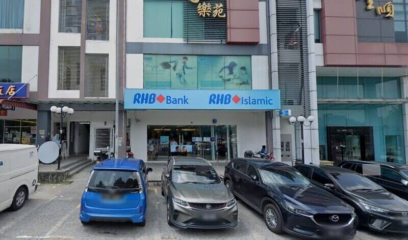 Pandangan hadapan cawangan RHB Bank dan RHB Islamic di cawangan kedai Bandar Mahkota Cheras dengan beberapa buah kereta diletakkan di tempat letak kereta di hadapannya.