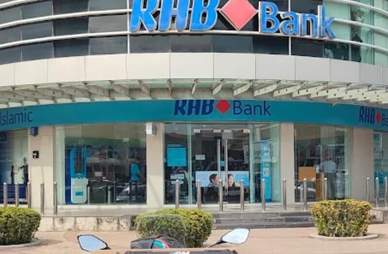 Pandangan hadapan cawangan RHB Bank IOI Boulevard dengan pintu masuk kaca dan papan tanda logo RHB Bank