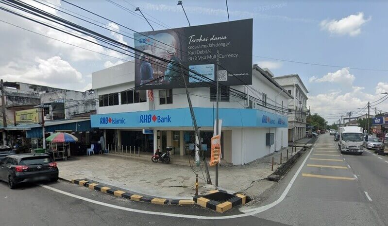 Pandangan luar bangunan cawangan RHB Bank dan RHB Islamic dua tingkat di persimpangan jalan dengan papan iklan besar di bahagian atas bangunan