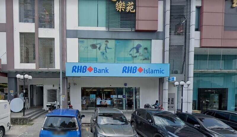Pandangan luar kedai RHB Bank dan cawangan RHB Islamic di Bandar Mahkota Cheras, menampilkan papan tanda biru dan kereta yang diletakkan di hadapan