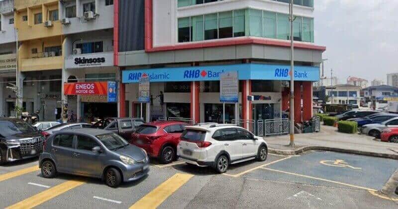 Pandangan luar RHB Bank dan cawangan RHB Islamic yang terletak di satu sudut di Damansara Utama, menampilkan papan tanda biru dan tempat letak kereta di tepi jalan