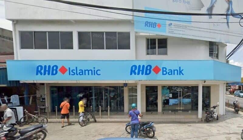 Pemandangan luar Bank RHB dan cawangan RHB Islamic di Kampung Baru Sungai Buloh, menampilkan bangunan putih dua tingkat dengan papan tanda biru muda yang menonjol dan kedai kaca