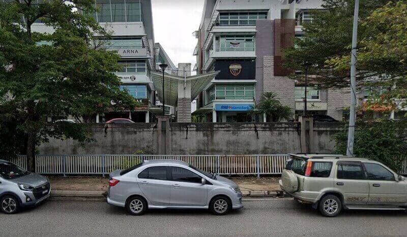 Pemandangan aras jalan cawangan RHB Islamic Bank di Laman Seri Business Park, memaparkan papan tanda biru bank pada bangunan pejabat bertingkat moden dengan kereta yang diletakkan di tepi jalan di latar depan