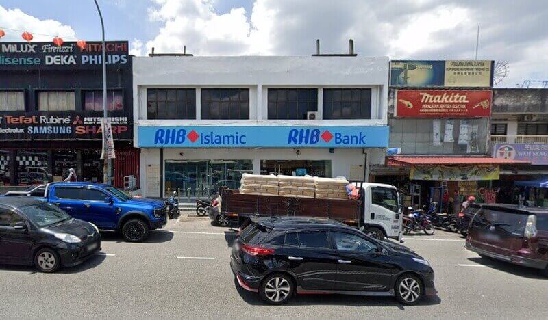 Pandangan luar cawangan RHB Bank dan RHB Islamic yang terletak di barisan komersial di Seri Kembangan, dengan beberapa buah kereta dan sebuah trak penghantaran diletakkan di jalan di hadapan