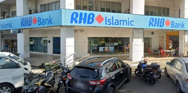 Pandangan luar RHB Bank dan cawangan RHB Islamic di Taman Sungai Besi, menampilkan papan tanda kedai berwarna biru muda, tingkap kaca dan kereta serta motosikal yang diletakkan di latar depan
