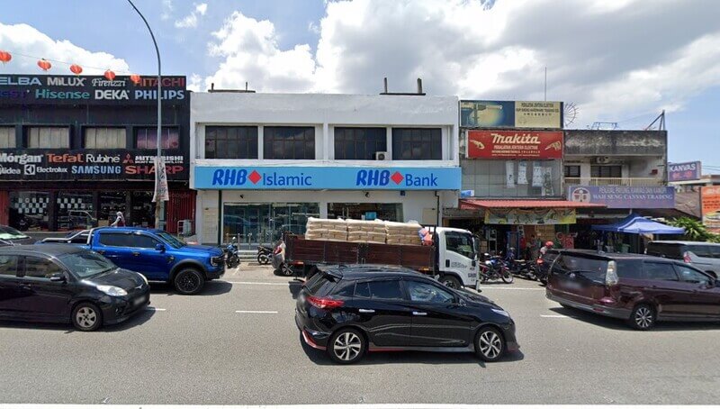 Pandangan hadapan cawangan RHB Bank di Seri Kembangandan RHB Islamic dua tingkat di deretan kedai tepi jalan yang sibuk dengan kenderaan