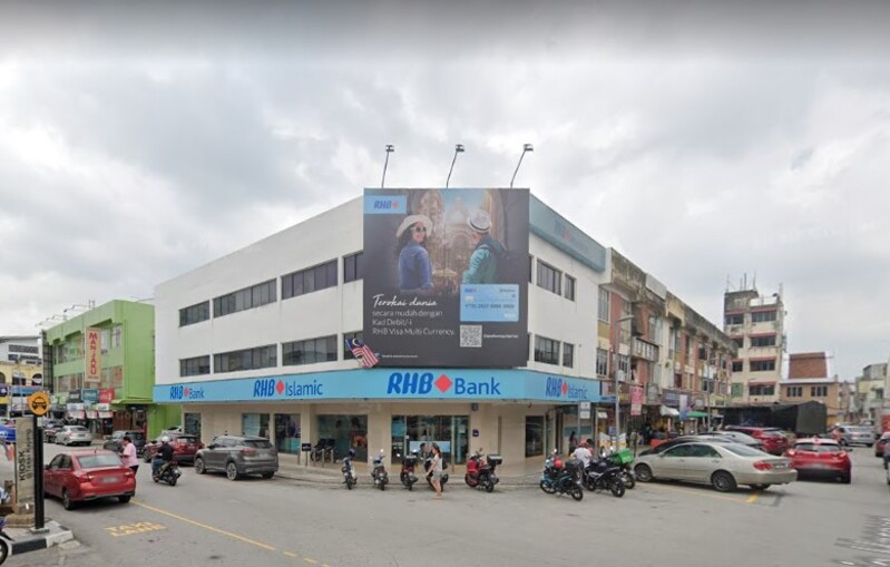Bangunan cawangan RHB Bank Kajang dan RHB Islamic di persimpangan jalan dengan papan iklan besar promosi Kad Debit/-i RHB Visa Multi Currency pada dinding cawangan