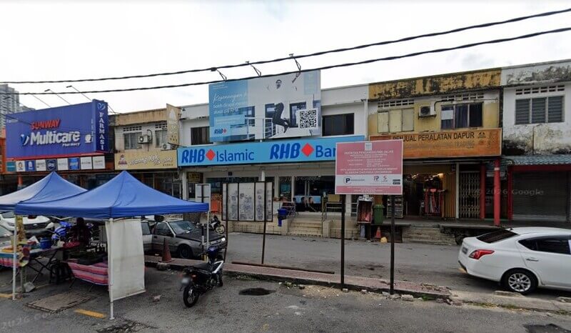 Pemandangan deretan kedai yang menampilkan cawangan RHB Bank dan RHB Islamic, Farmasi Sunway Multicare, serta khemah jualan di tepi jalan
