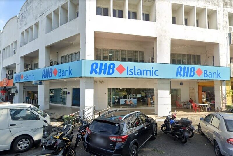 Pandangan luar RHB Bank dan cawangan RHB Islamic di Taman Sungai Besi, menampilkan papan tanda kedai berwarna biru muda, tingkap kaca dan kereta serta motosikal yang diletakkan di latar depan